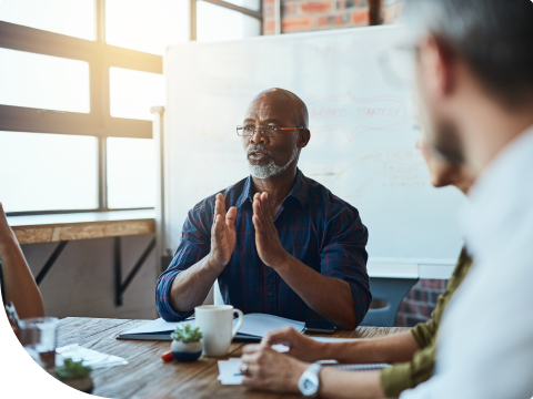 businessman in meeting talking to a team of employees