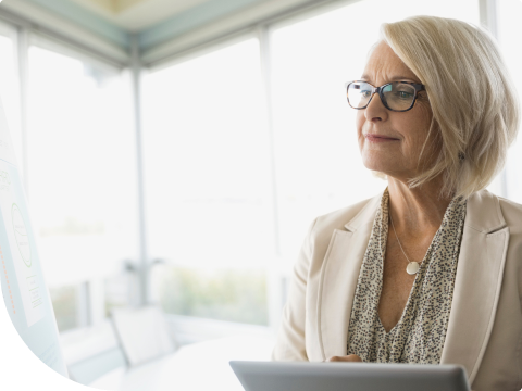 middle aged woman logging into her wealth management portfolio on laptop