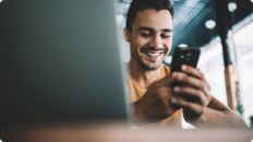 man on cell phone with laptop in front of him