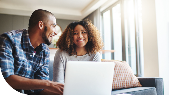 two people on couch in front of laptop