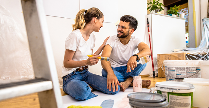 couple planning home remodeling project with paint cans all around