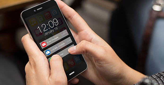 Close up of hands holding smartphone receiving real time notifications