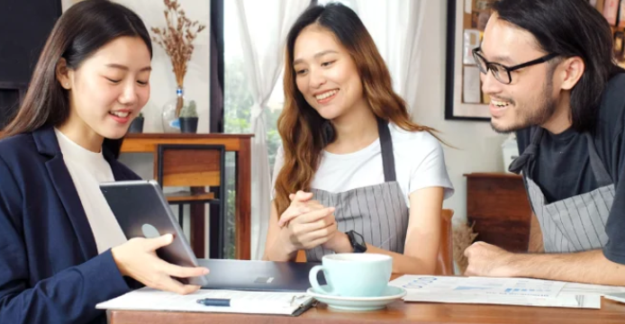 two small business owners being shown banking options on tablet