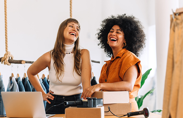 two businesswoman smiling and laughing at their workshop