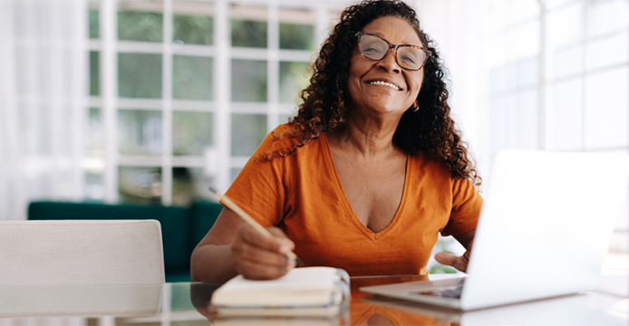 woman in front of laptop with paper in front of her