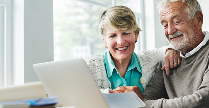 couple going over retirement savings statements and smiling