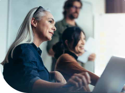 two women at desk with laptops