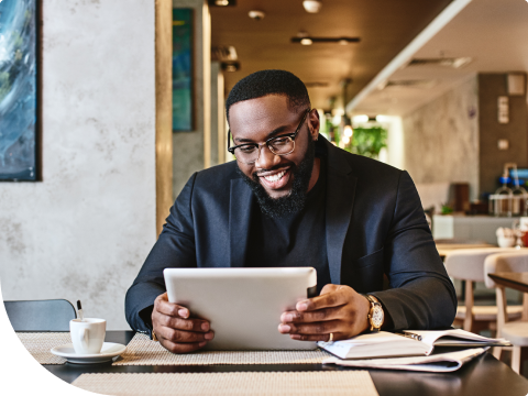businessman smiling while looking at banking on smart tablet