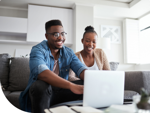 Couple sitting on couch logging onto online banking