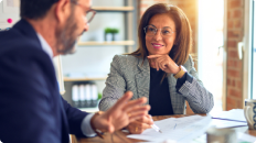 man and woman sitting at a desk talking 