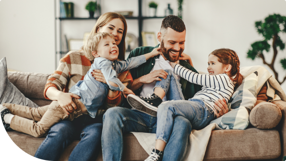 family of four sitting on a couch playing