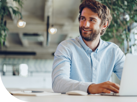 young businessman looking off into distance while on laptop
