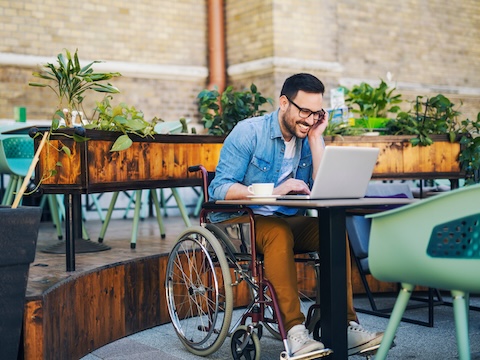 Man in wheelchair looking for employment on laptop