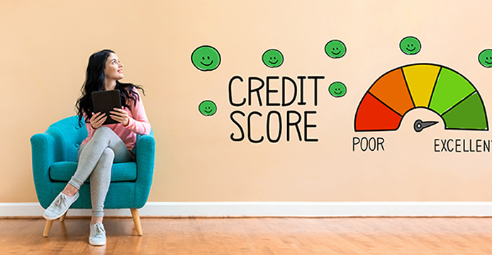 young woman sitting no chair looking at the words credit score on the wall with arrow of the credit score wheel pointing to excellent