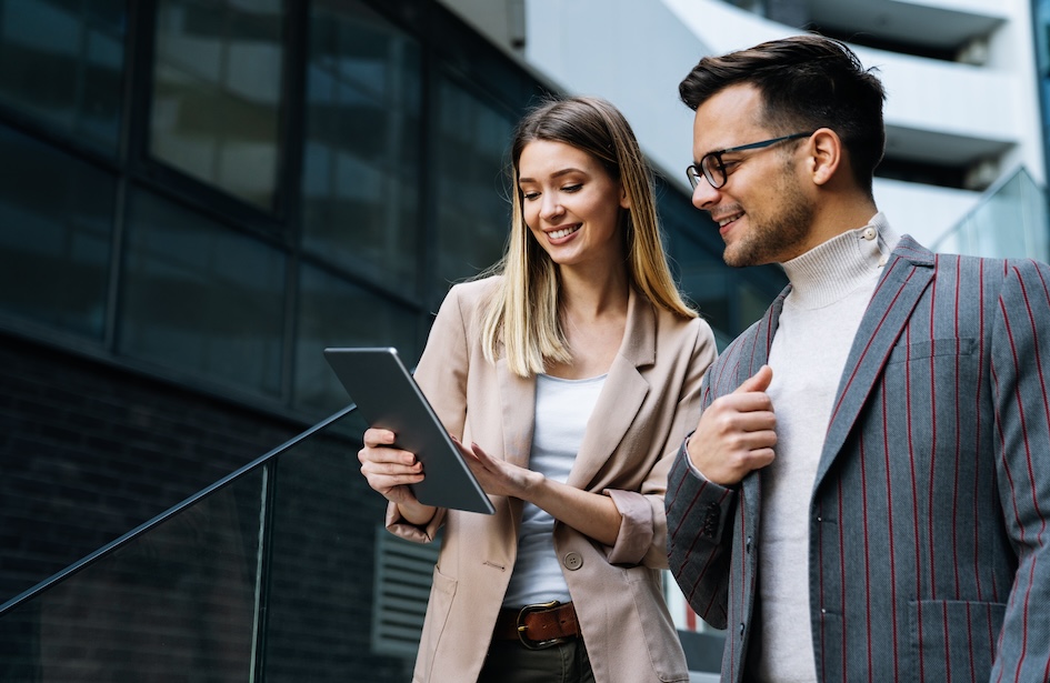 two businesspeople one holding tablet while using BNC National Bank online banking platform