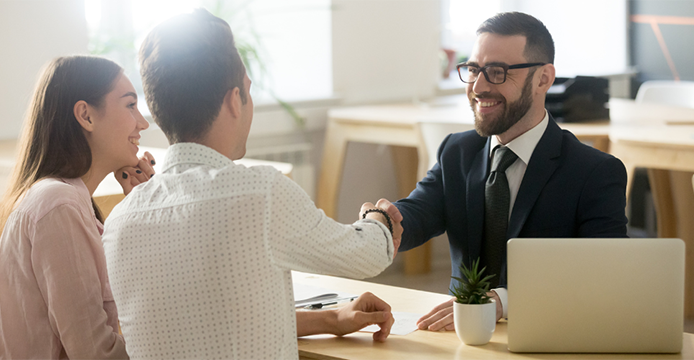 couple shaking hands with banker