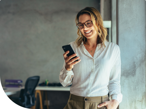 woman standing in office building looking at cell phone