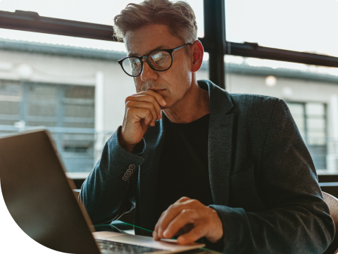 man with glasses at desk in front of computer