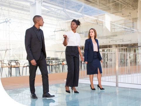Three businesspeople walking through commercial building