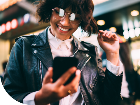 young woman smiling looking at finances on her smart phone
